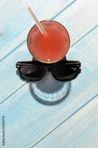 creative summer smile. red drink in glass on blue summer table