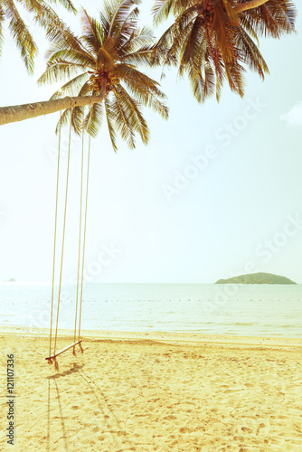 Fototapeta Naklejka Na Ścianę i Meble -  Coconut tree and swing on beach with vintage toned