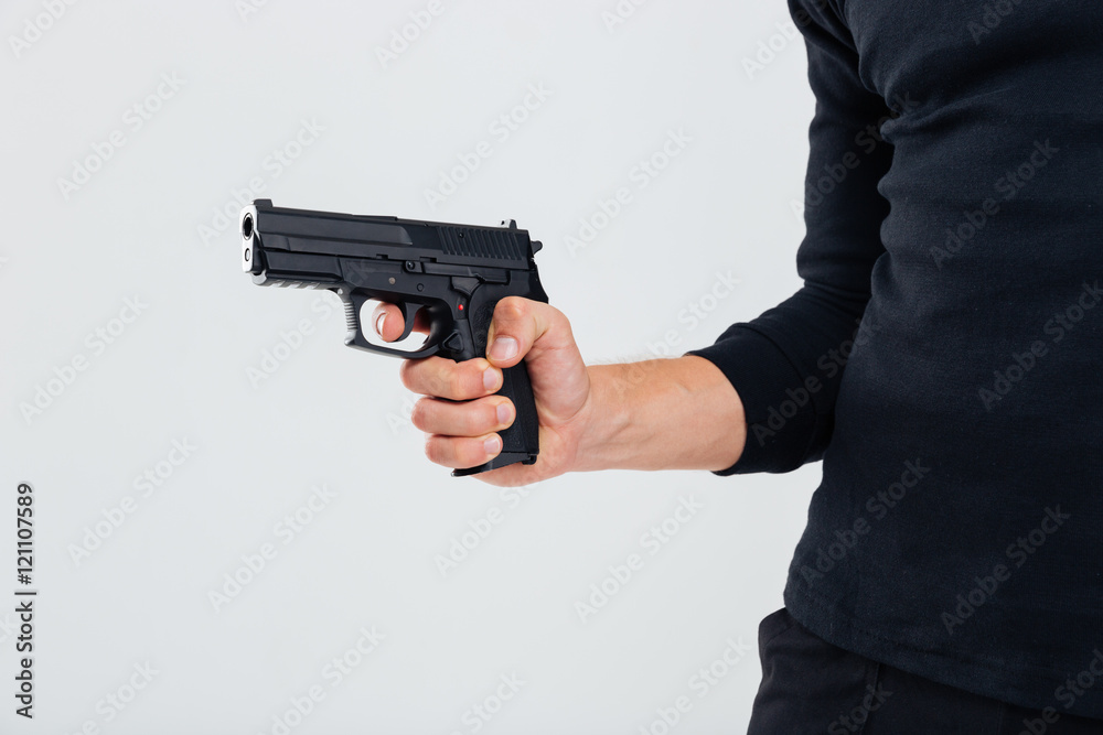 Closeup of man in black clothes holding a gun Closeup of man in black clothes holding a gun