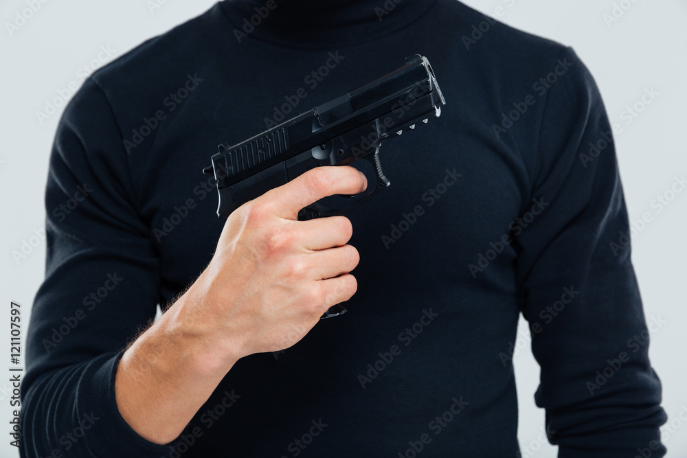 Man in black clothes standing and holding a gun Man in black clothes standing and holding a gun