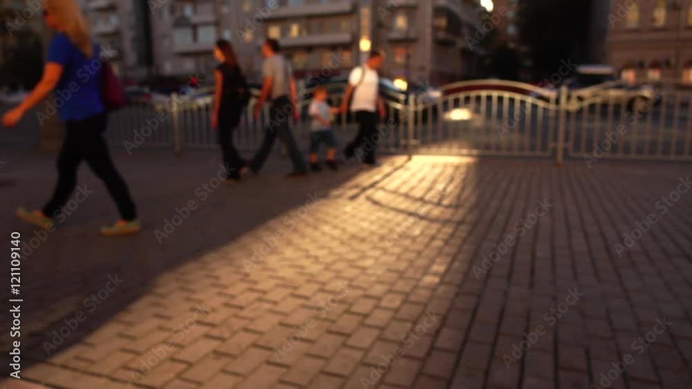 Defocused street in the evening. Cars and walking people. 4K background bokeh wide shot Defocused street in the evening. Cars and walking people. 4K background bokeh wide shot