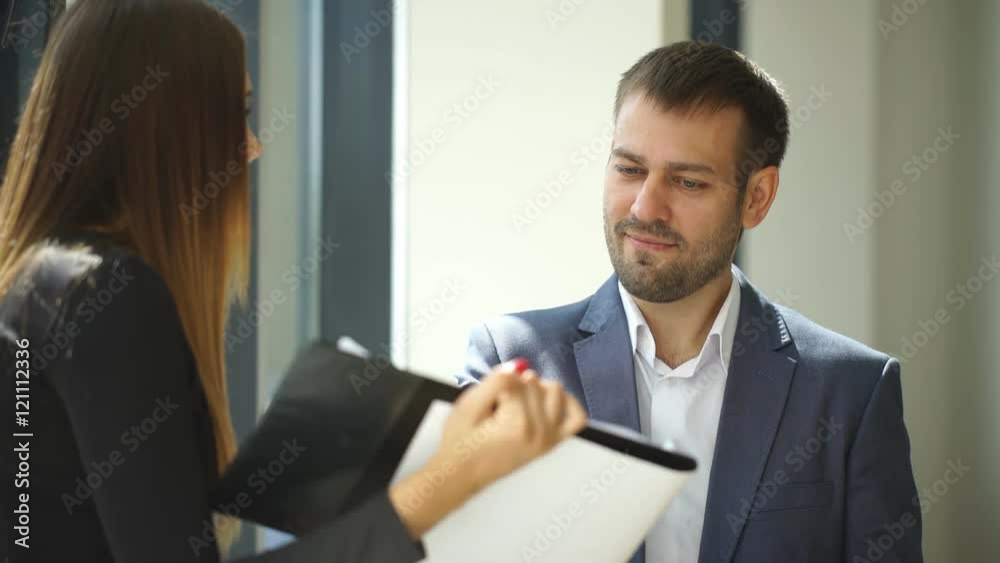 businesswoman and businessman standing in office and discussing business ideas businesswoman and businessman standing in office and discussing business ideas