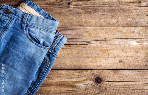 Jeans on a wooden background. The upper part. Clothing, fashion, style, lifestyle