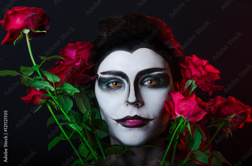 Halloween. Beautiful face-art girl and red roses Halloween. Beautiful face-art girl and red roses