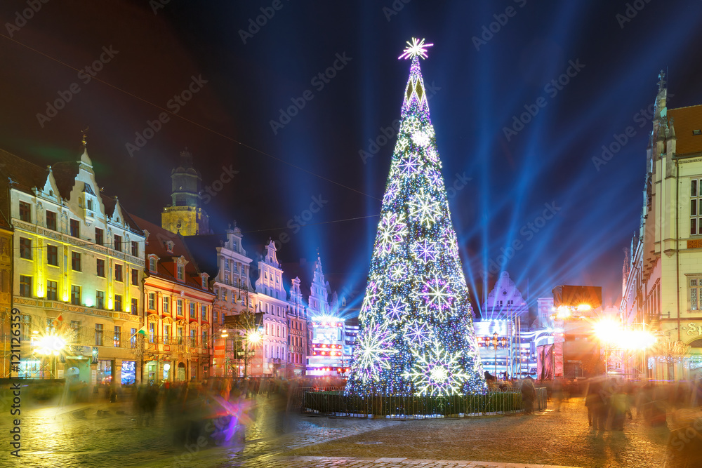 Fototapeta premium Christmas tree and light laser show on Market Square at christmas night in Wroclaw, Poland