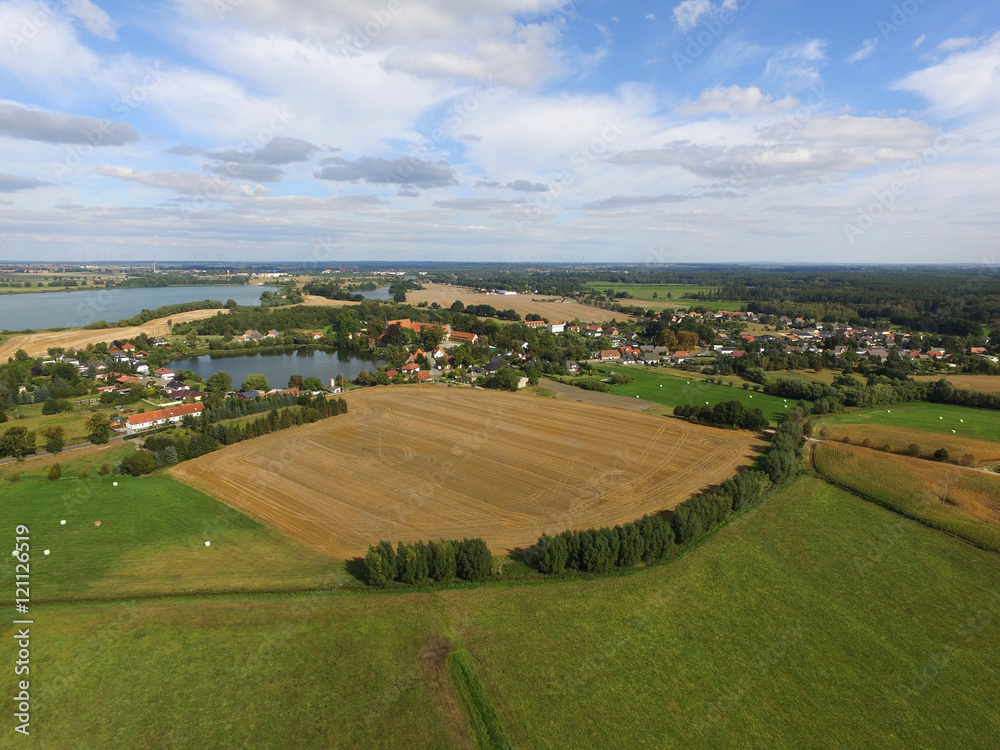 aerial view of a small village with agricultural fields and lakes in germany