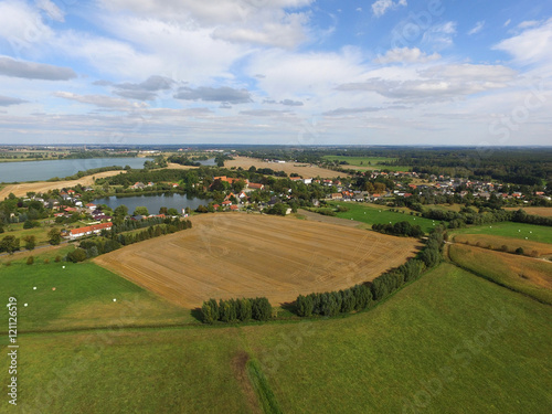 aerial view of a small village with agricultural fields and lakes in germany