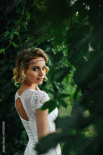 Woman with deep dark eyes looks over her shoulder standing betwe
