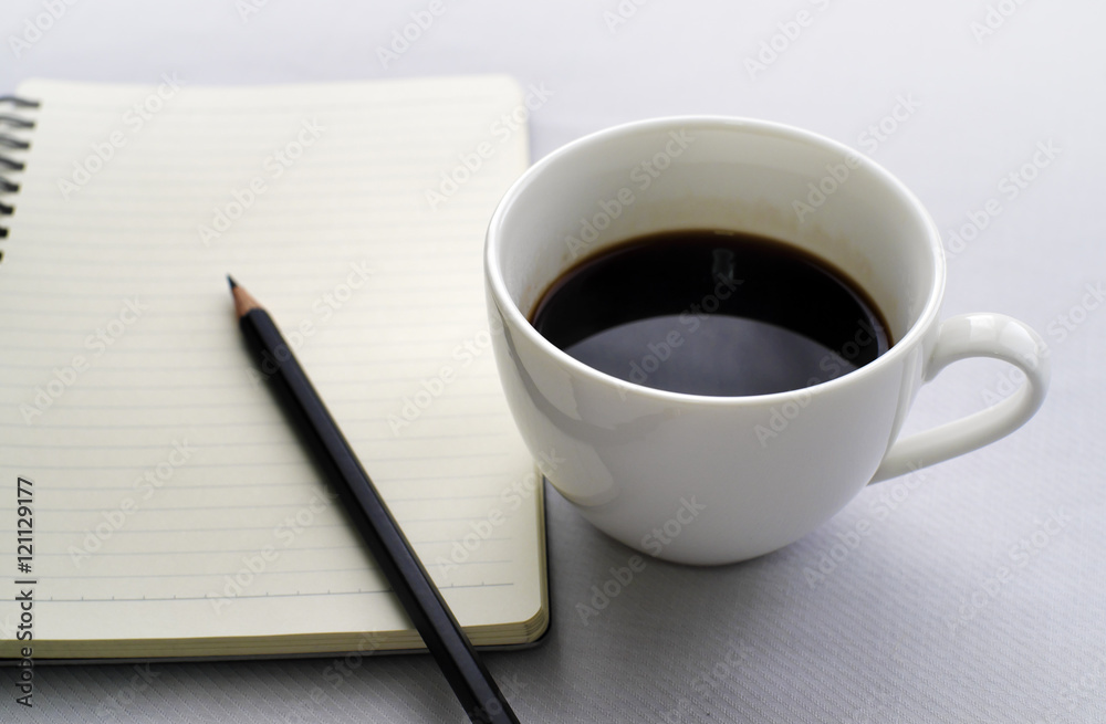 Coffee in white cup with Journal book and pencil Coffee in white cup with Journal book and pencil