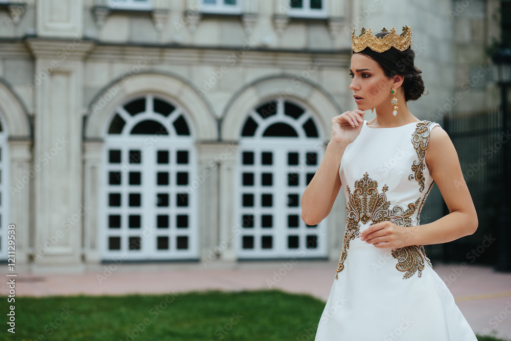 Model looks worried posing on the backyard of an old castle