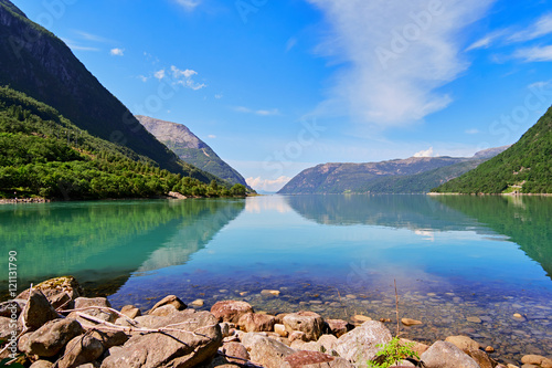 Look over the lake Austrepollen, in the Mauranger area of Norway, where the tree covered mountain sides runs all the way in to the calm water