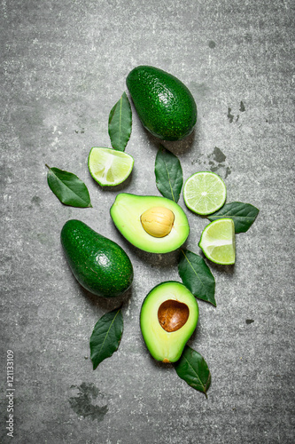 Avocado and lime . On stone background.