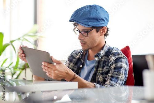 man with tablet pc sitting at cafe table