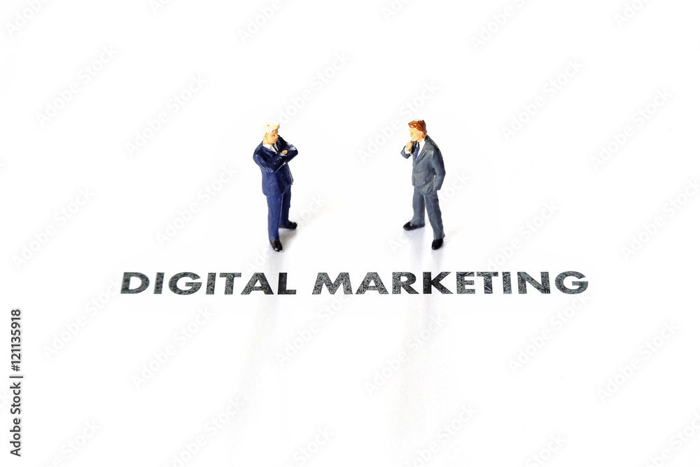 Miniature business man over digital marketing text Miniature business man over digital marketing text