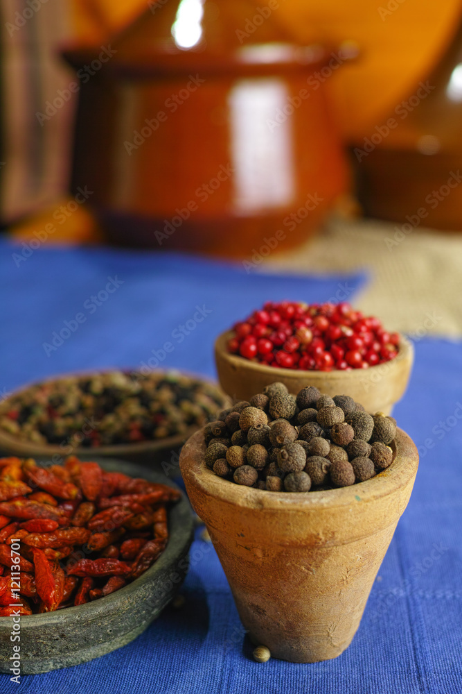 Dried red, hot chili, black, white peppers in old clay bowls in oriental style Dried red, hot chili, black, white peppers in old clay bowls in oriental style