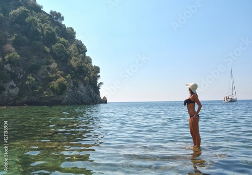 Woman with hat relaxing in blue water
