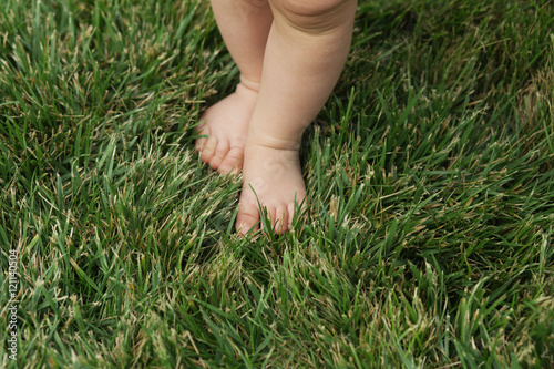 Baby standing barefoot on the green lawn © nata_zhekova