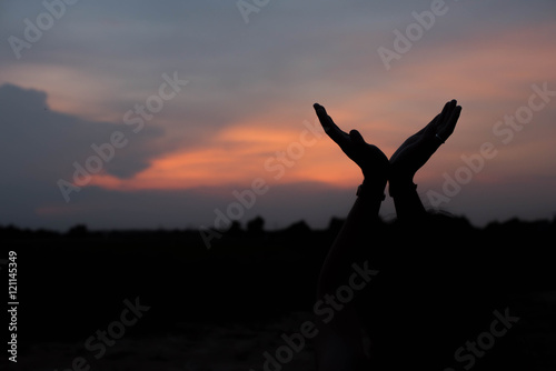 silhouette of woman both hands and sunset light.