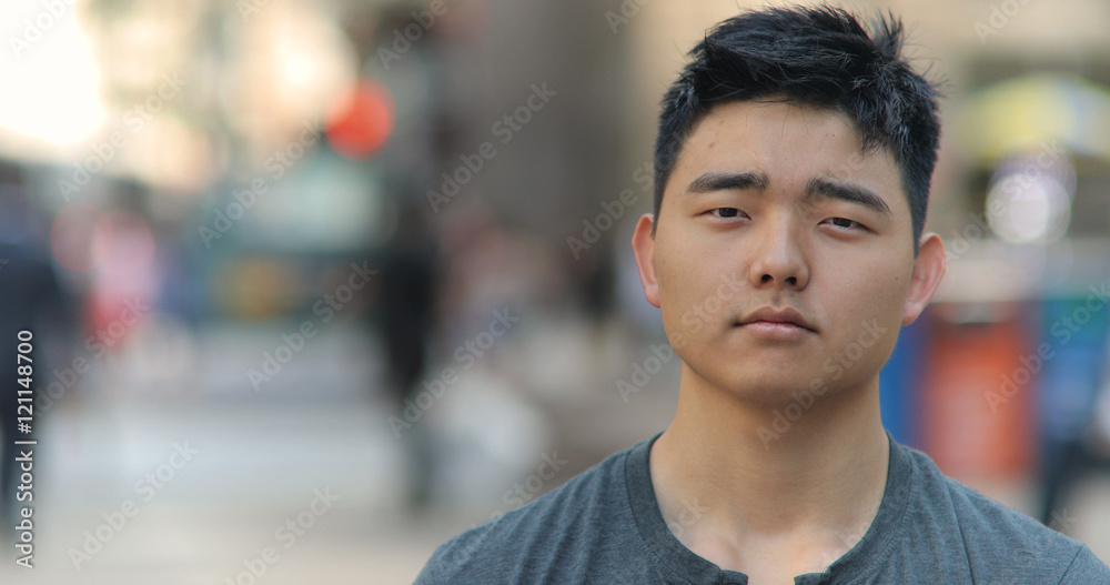 Young Asian man in city face portrait Young Asian man in city face portrait