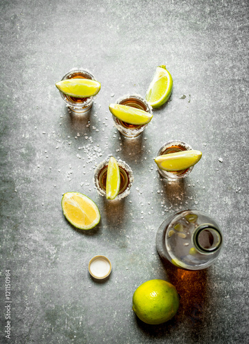 bottle of tequila with lime and salt.
