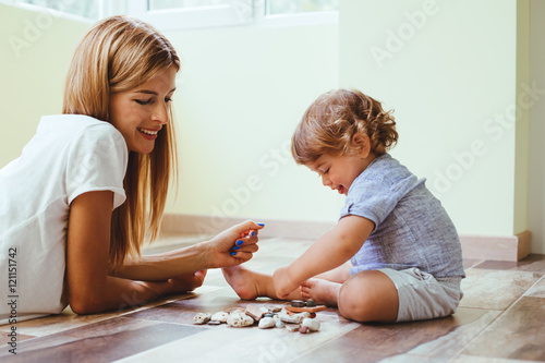 Mom playing with son on a floor photo