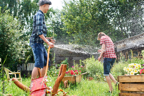 Photography Brothers having fun splash each other with water in the village