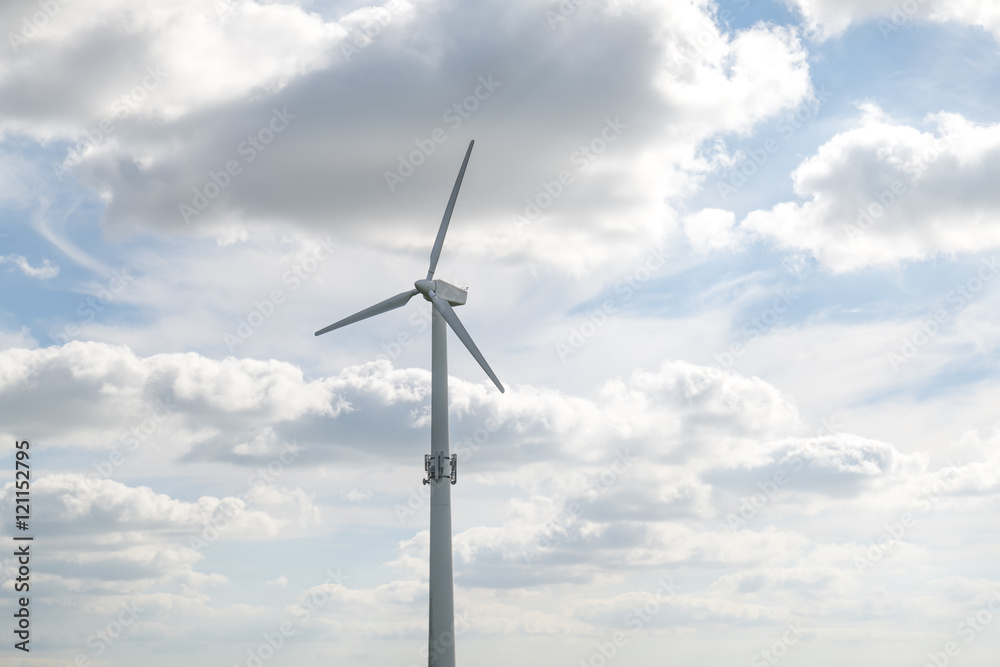 Wind mill against blue sky with clouds for energy production