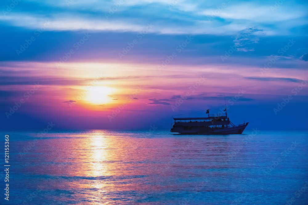 Tropical colorful dramatic sunset with cloudy sky and silhouette of the ship on the horizon. Evening calm on the Gulf of Thailand. Bright afterglow. Tropical colorful dramatic sunset with cloudy sky and silhouette of the ship on the horizon. Evening calm on the Gulf of Thailand. Bright afterglow.