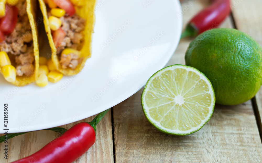 Fresh lime on wooden table, mexican tacos and red chili pepper as background Fresh lime on wooden table, mexican tacos and red chili pepper as background
