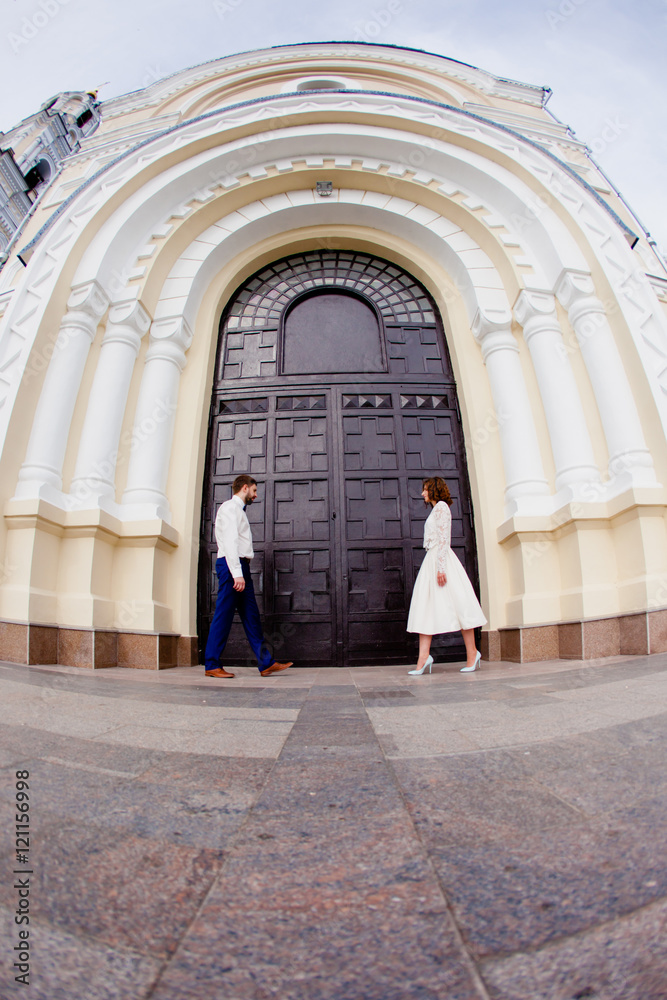 The bride and groom standing next to the large iron gates The bride and groom standing next to the large iron gates