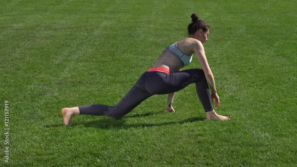 Slim woman exercising on mat in park Slim woman exercising on mat in park