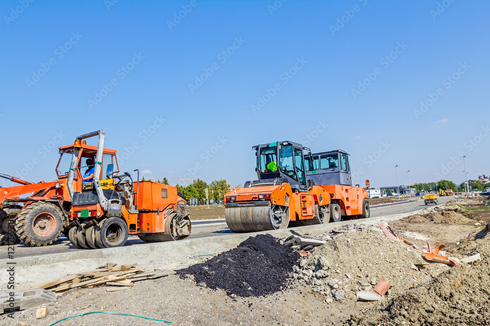 Steamrollers are parked at building site. Machinery for road con Steamrollers are parked at building site. Machinery for road con