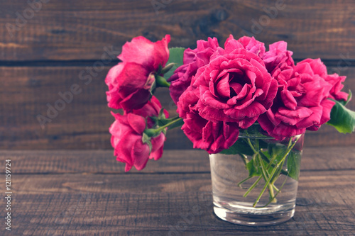 Roses on dark rustic wooden background. Valentine's Day and Moth