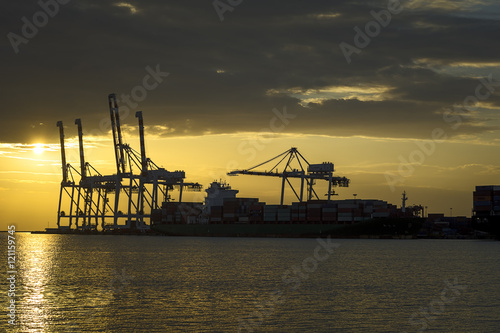 Cargo ship loaded in the shipping container terminal, Cargo container ship for shipping concept in sunset