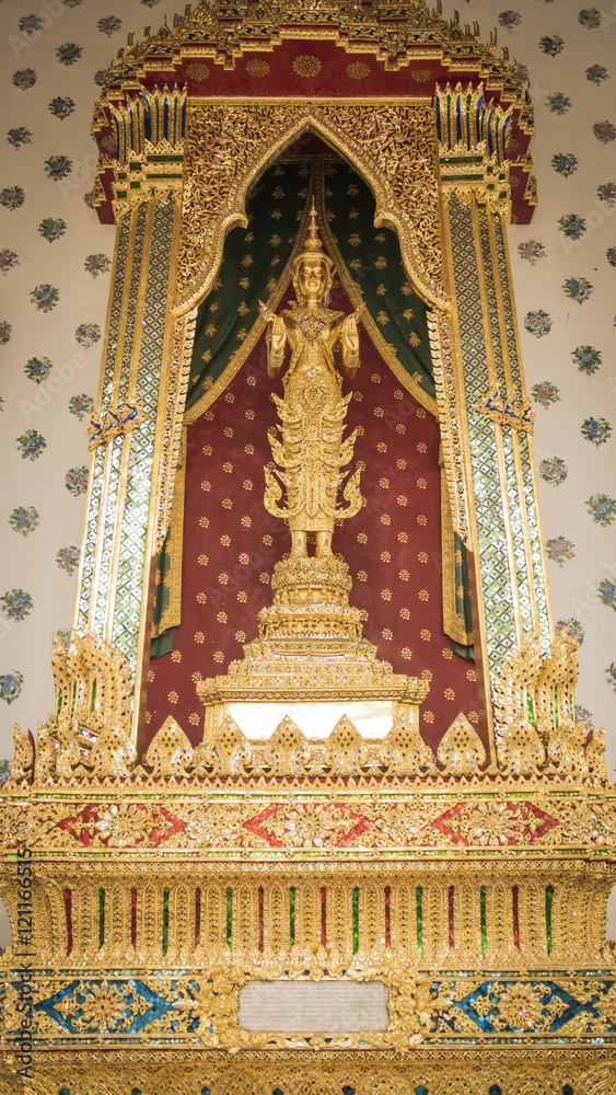 Golden angel statue and  Thai art architecture detail main ordination hall in Wat Arun buddhist temple in Bangkok, Thailand