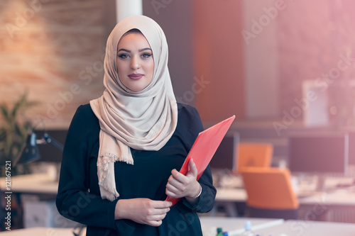 Arabian business woman holding a folder in modern startup office photo