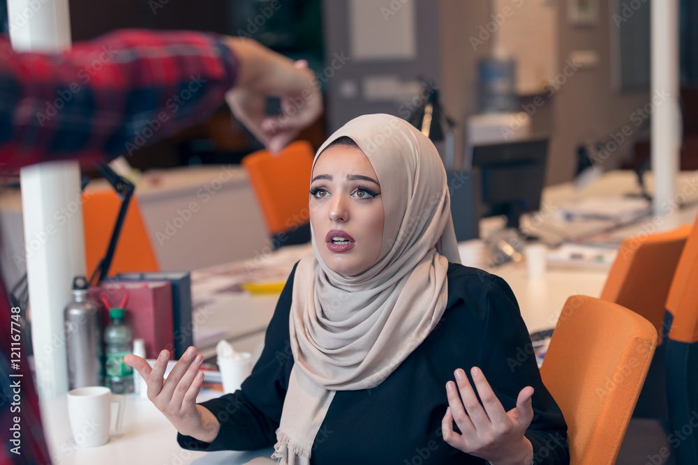 Worried arabic businesswoman wearing hijab receiving a notification from a colleague in her workplace at office