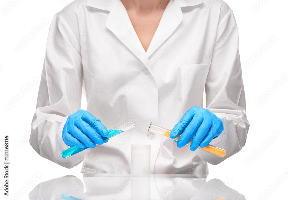 Female holding test tubes over measuring cup Female holding test tubes over measuring cup