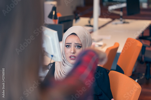 Worried arabic businesswoman wearing hijab receiving a notification from a colleague in her workplace at office