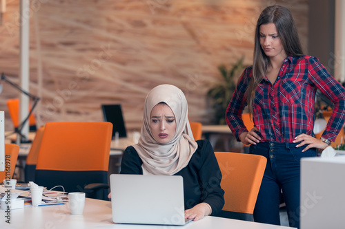 Worried arabic businesswoman wearing hijab receiving a notification from a colleague in her workplace at office