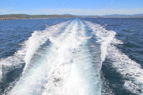 White foaming wake of boat cruising through blue Mediterranean sea
