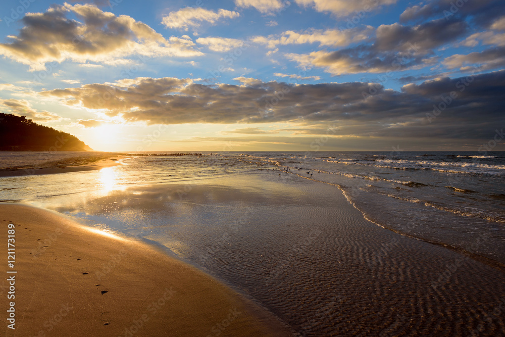 Beautiful sandy Debki beach with waves at sunset time.  Baltic Sea, Poland. 