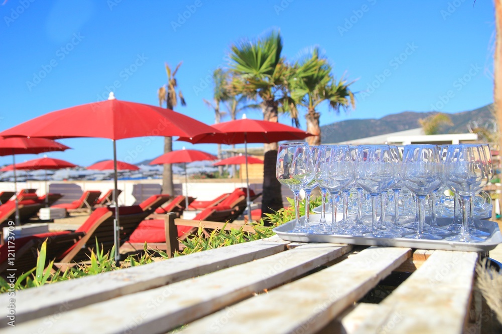 Wine glasses on a wooden table in a tropical paradise beach bar and restaurant Wine glasses on a wooden table in a tropical paradise beach bar and restaurant