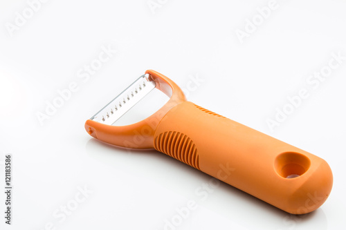 Canvas Print Vegetable and potato peeler with orange handle on white backgrou