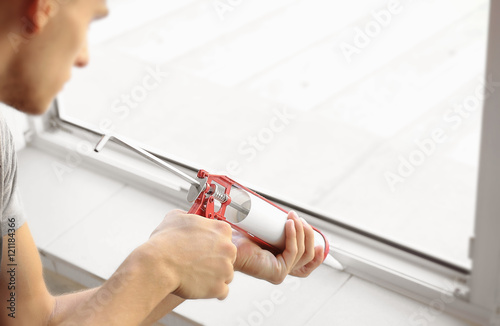 Construction worker installing window in house