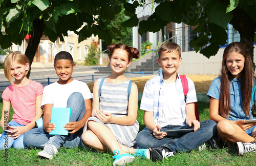 Schoolchildren sitting on g...