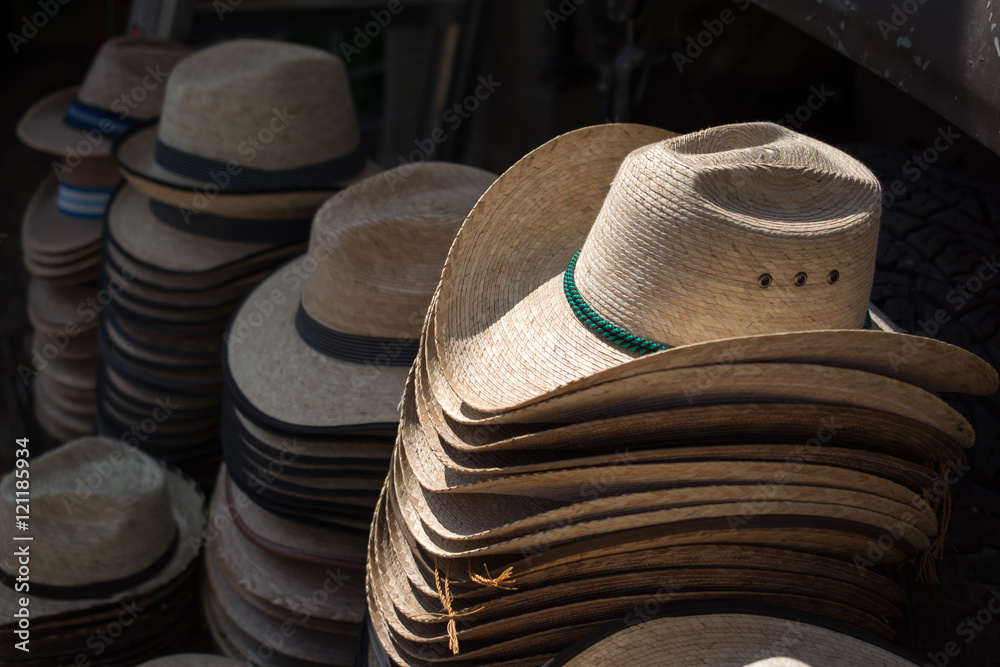 Sombreros de paja ordenados en columnas para la venta.