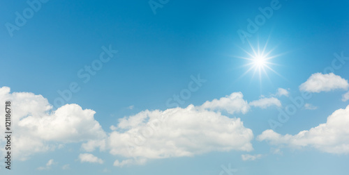 Blue sky with clouds and sun reflection