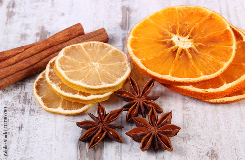 Slices of dried lemon, orange and spices on old wooden background