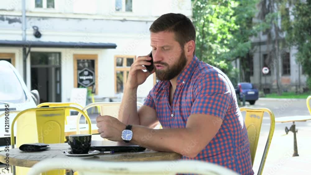 Young man talking by smartphone in cafe. He is sitting at the table in cafe. He is young and has beard. Man is dressed in checkered shirt.
Young man talking by smartphone in cafe. He is sitting at the table in cafe. He is young and has beard. Man is dressed in checkered shirt.